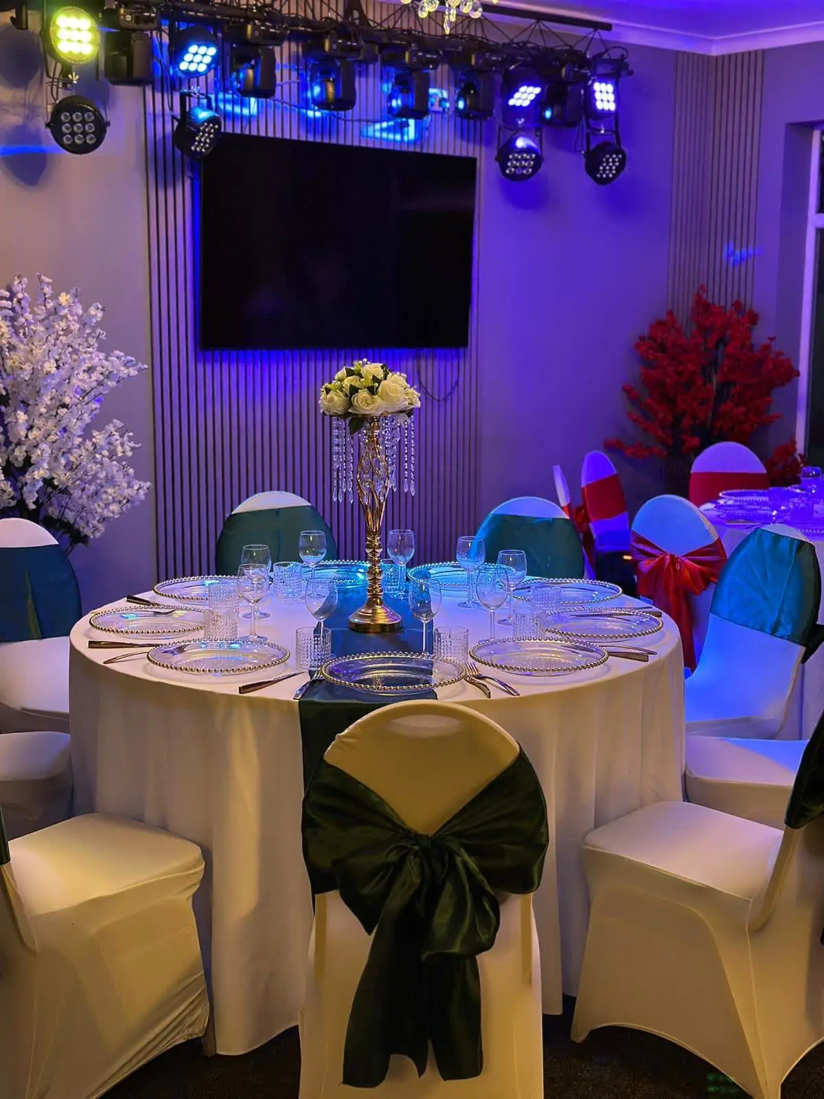 Gold Hall set with emerald green chair sashes, with the lighting truss and large screen at the far end