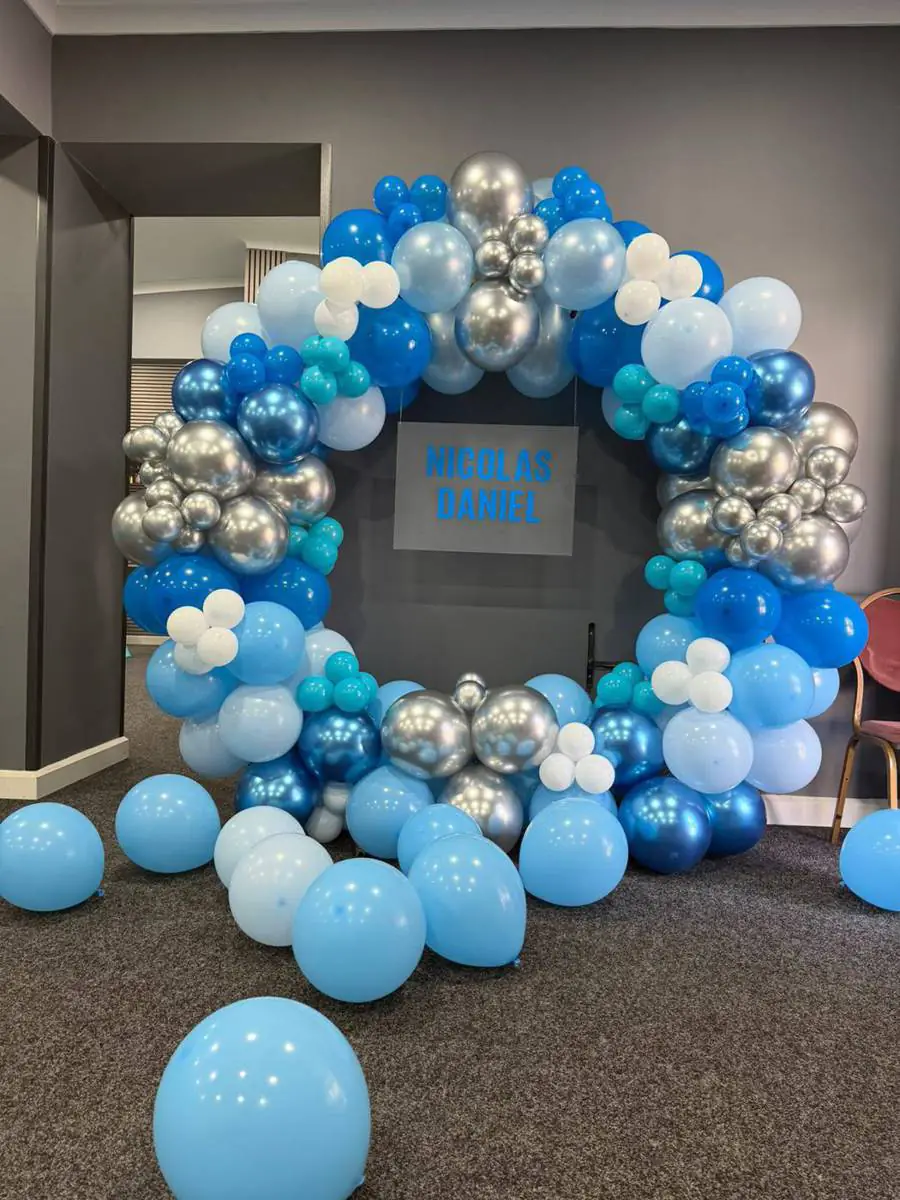 Blue and silver balloon hoop with matching balloons arranged on the floor